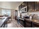 This kitchen features dark cabinets, granite countertops, stainless appliances and nearby dining area at 2200 Cadman St, Berthoud, CO 80513