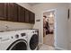 Modern laundry room with a front-load washer and dryer, dark cabinets, and an adjacent closet at 2200 Cadman St, Berthoud, CO 80513