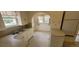 A cozy kitchen has vintage countertops and cabinets plus an arched breakfast nook with a window at 9120 Elm Ct, Denver, CO 80260