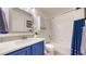 Well-lit bathroom with blue vanity, white countertops, and shower/tub combo with a white tile surround at 20855 Omaha Ave, Parker, CO 80138