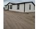 Exterior angle view of a house with white paint, black trim, gravel, and tire tracks at 7486 Harold St, Fort Lupton, CO 80621