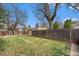 Spacious backyard with green grass, privacy fence, and mature trees, perfect for outdoor activities at 3726 Decatur St, Denver, CO 80211