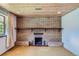 Spacious finished basement area featuring a brick fireplace, wood paneling, and cozy atmosphere at 7785 Westview Dr, Lakewood, CO 80214