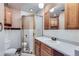 Bathroom with tiled shower, toilet, and oak vanity at 7785 Westview Dr, Lakewood, CO 80214