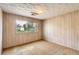 Bedroom featuring paneled walls, textured ceiling, and view to the backyard at 7785 Westview Dr, Lakewood, CO 80214