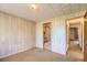 Bedroom with paneled walls leading to ensuite bathroom at 7785 Westview Dr, Lakewood, CO 80214