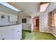 Retro kitchen with green floor, floral wallpaper, and white cabinets at 7785 Westview Dr, Lakewood, CO 80214