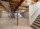 Unfinished basement with concrete floor, exposed beams, and staircase leading to the upper level at 8579 S Miller Way, Littleton, CO 80127