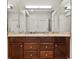 A bathroom vanity with dual sinks, granite counters and dark wood cabinetry at 8579 S Miller Way, Littleton, CO 80127