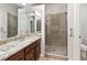 Bright bathroom featuring a glass shower door, dual sinks and granite counters at 8579 S Miller Way, Littleton, CO 80127