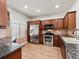 Modern kitchen featuring stainless steel appliances, granite countertops, and hardwood floors providing functionality at 8579 S Miller Way, Littleton, CO 80127