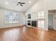 Open living room features wood floors, a vaulted ceiling, a fireplace and built-in shelving at 8579 S Miller Way, Littleton, CO 80127