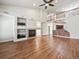 Expansive living room featuring hardwood floors, fireplace, and open layout with views of the kitchen and upper level at 8579 S Miller Way, Littleton, CO 80127