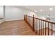 Spacious loft area features laminate flooring, neutral walls, and a wooden railing at 8579 S Miller Way, Littleton, CO 80127