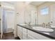Bright bathroom featuring a double vanity, white cabinets, and a shower-tub combo at 12797 Clearview St, Firestone, CO 80504