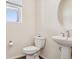 Stylish powder room with pedestal sink, round mirror and natural light at 12797 Clearview St, Firestone, CO 80504