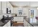 Bright kitchen with white cabinets, stainless steel appliances, granite countertops and an adjacent outdoor area at 12797 Clearview St, Firestone, CO 80504
