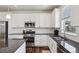 Bright kitchen featuring white cabinets, stainless steel appliances, and a dark countertop at 12797 Clearview St, Firestone, CO 80504