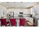 Modern kitchen featuring white cabinets, stainless steel appliances, granite countertops and stylish bar stools at 12797 Clearview St, Firestone, CO 80504