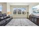 Bright living room featuring hardwood floors, large windows, modern decor, and a comfortable leather sofa at 12797 Clearview St, Firestone, CO 80504