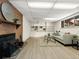 Basement living area with a brick fireplace, comfortable seating, and bright lighting at 1075 Dudley St, Lakewood, CO 80215