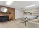 Basement living area with brick fireplace, wood-burning stove, and built-in shelving at 1075 Dudley St, Lakewood, CO 80215