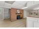 Cozy basement with a brick fireplace, built-in shelving, and updated flooring for a warm, inviting atmosphere at 1075 Dudley St, Lakewood, CO 80215