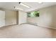 Unfinished basement featuring neutral carpet, closet, and natural light from window at 1075 Dudley St, Lakewood, CO 80215