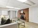 Basement living area with a brick fireplace, comfortable seating, and bright lighting at 1075 Dudley St, Lakewood, CO 80215
