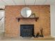 Close-up of the basement fireplace with brick surround and dark wood mantle at 1075 Dudley St, Lakewood, CO 80215