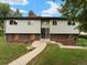 Charming two-story home with light green siding and manicured front yard and walkway leading to the front door at 1075 Dudley St, Lakewood, CO 80215