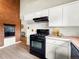Clean kitchen featuring stainless steel appliances, brick accent wall, and neutral countertops at 1075 Dudley St, Lakewood, CO 80215