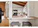 Pass-through kitchen view with barstool seating, white cabinetry, and adjacent living spaces at 1075 Dudley St, Lakewood, CO 80215