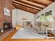 Inviting living room with hardwood floors, wood ceiling beams, a brick fireplace, and comfortable seating area at 1075 Dudley St, Lakewood, CO 80215