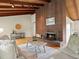 Inviting living room showcasing wood floors, brick fireplace, comfortable sofas, and a view into the dining area at 1075 Dudley St, Lakewood, CO 80215