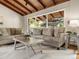 Comfortable living room with hardwood floors, exposed wood beams, and a view of the green, tree-filled outdoors at 1075 Dudley St, Lakewood, CO 80215