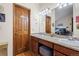 Well-lit bathroom with granite countertops, double sinks, and wood cabinets at 15149 E Princeton Pl # B, Aurora, CO 80014