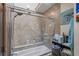 Bathroom with glass-door shower, tiled walls, and built-in shelves at 15149 E Princeton Pl # B, Aurora, CO 80014