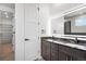 Modern bathroom featuring double vanity with granite countertop and walk-in closet at 995 Pinehurst Ct, Bennett, CO 80102