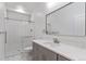 A modern bathroom with a glass shower door and a gray vanity with marble countertop at 995 Pinehurst Ct, Bennett, CO 80102