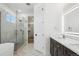Modern bathroom with double vanity, quartz countertop, and a walk-in shower with glass doors at 995 Pinehurst Ct, Bennett, CO 80102