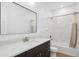 Bathroom with dark wood vanity, marble countertops, framed mirror, and shower over tub at 995 Pinehurst Ct, Bennett, CO 80102