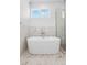 Modern bathroom featuring a white soaking tub and glass shower at 995 Pinehurst Ct, Bennett, CO 80102