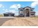 Two-story home with stone accents and a detached two-car garage at 995 Pinehurst Ct, Bennett, CO 80102