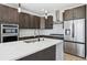 Close-up of a modern kitchen with a white countertop island and stainless appliances at 995 Pinehurst Ct, Bennett, CO 80102