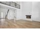 Open-concept living space featuring hardwood floors, a fireplace, and a modern design at 995 Pinehurst Ct, Bennett, CO 80102