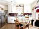 Bright eat-in kitchen with white cabinets, stainless steel appliances, and a cozy dining area at 1516 S Lowell Blvd, Denver, CO 80219