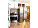 Modern kitchen with stainless steel appliances, including a refrigerator and gas range, with tile backsplash at 1516 S Lowell Blvd, Denver, CO 80219