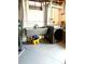 Functional laundry area with utility sink, modern washer, and grey painted floors at 1516 S Lowell Blvd, Denver, CO 80219