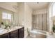 Bathroom featuring double sinks, granite counters, and a modern glass-enclosed shower at 303 Inverness S Way # 101, Englewood, CO 80112